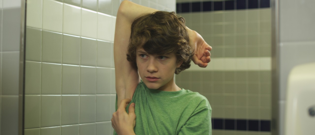 still from YEAH KOWALSKI! of 13-yr-old boy examining armpit hair in mirror