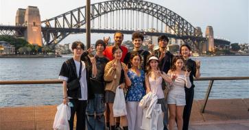 A group of UT Austin students pose in front of the Sydney Harbor Bridge in Sydney, Australia. 