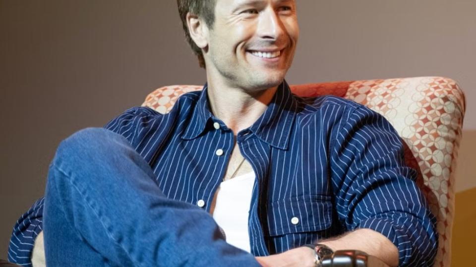 Glen Powell sits in an armchair during the Q&A portion of the screening event