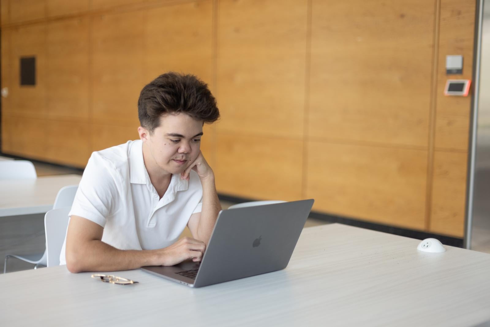 Gregory edits photos on his laptop in DMC