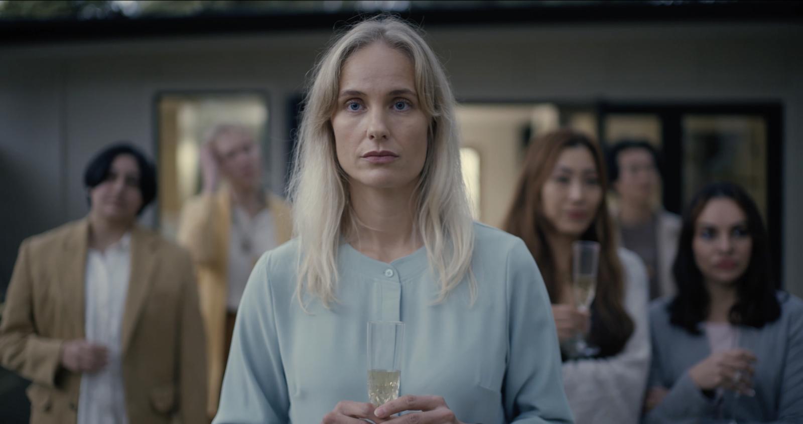 A still of Jennifer Saura's Film, "Donor" showing a woman holding a glass flute.