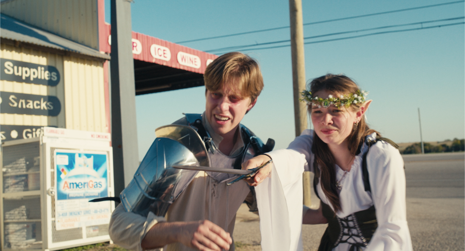 A still of Sawyer Goolsby's Film, "Knight of the Gas Staton" showing man and woman dressed in renaissance fair attire outside of a gas station.