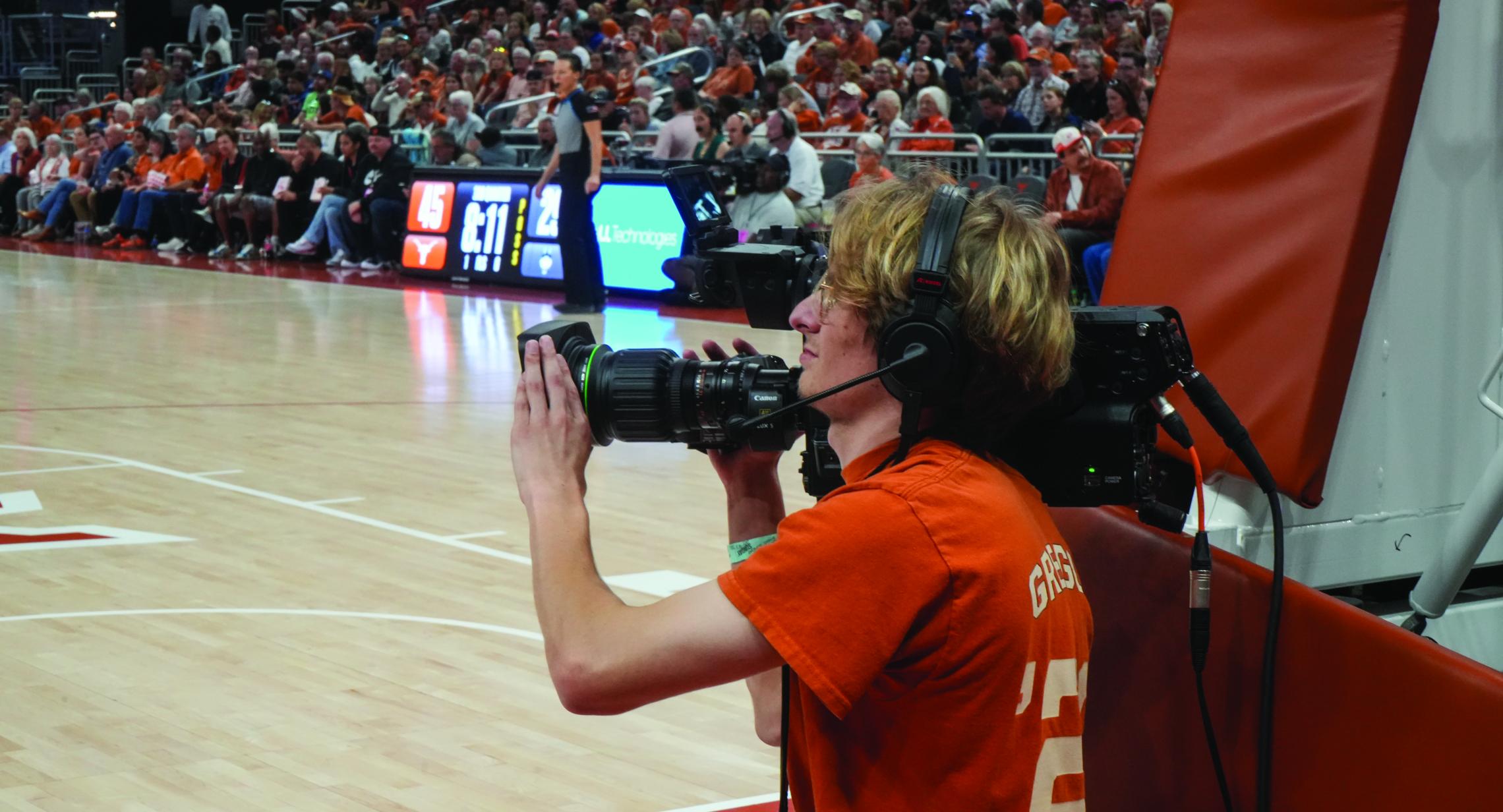 student filming basketball game