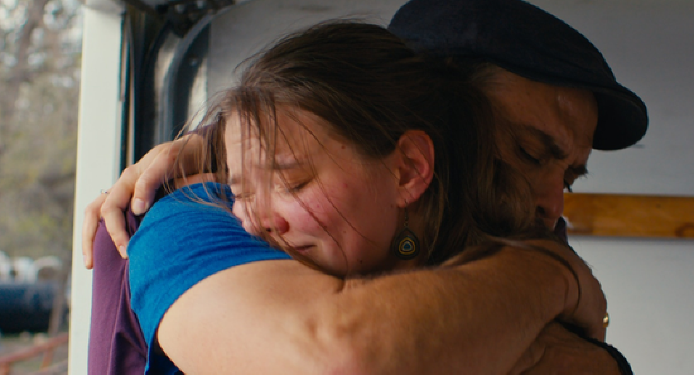 Two people embrace.