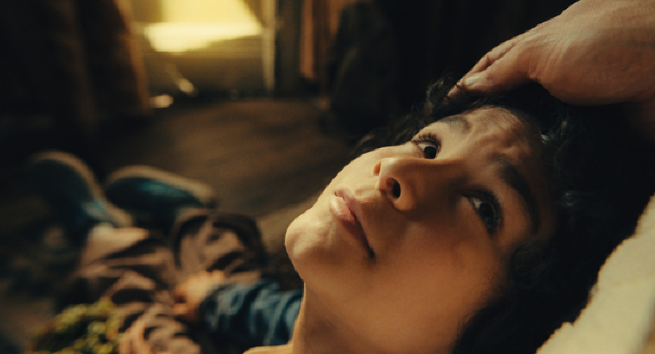 Screencap of the short film "Piojo". A child looks up toward someone.. 