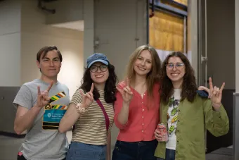 students doing hook em sign