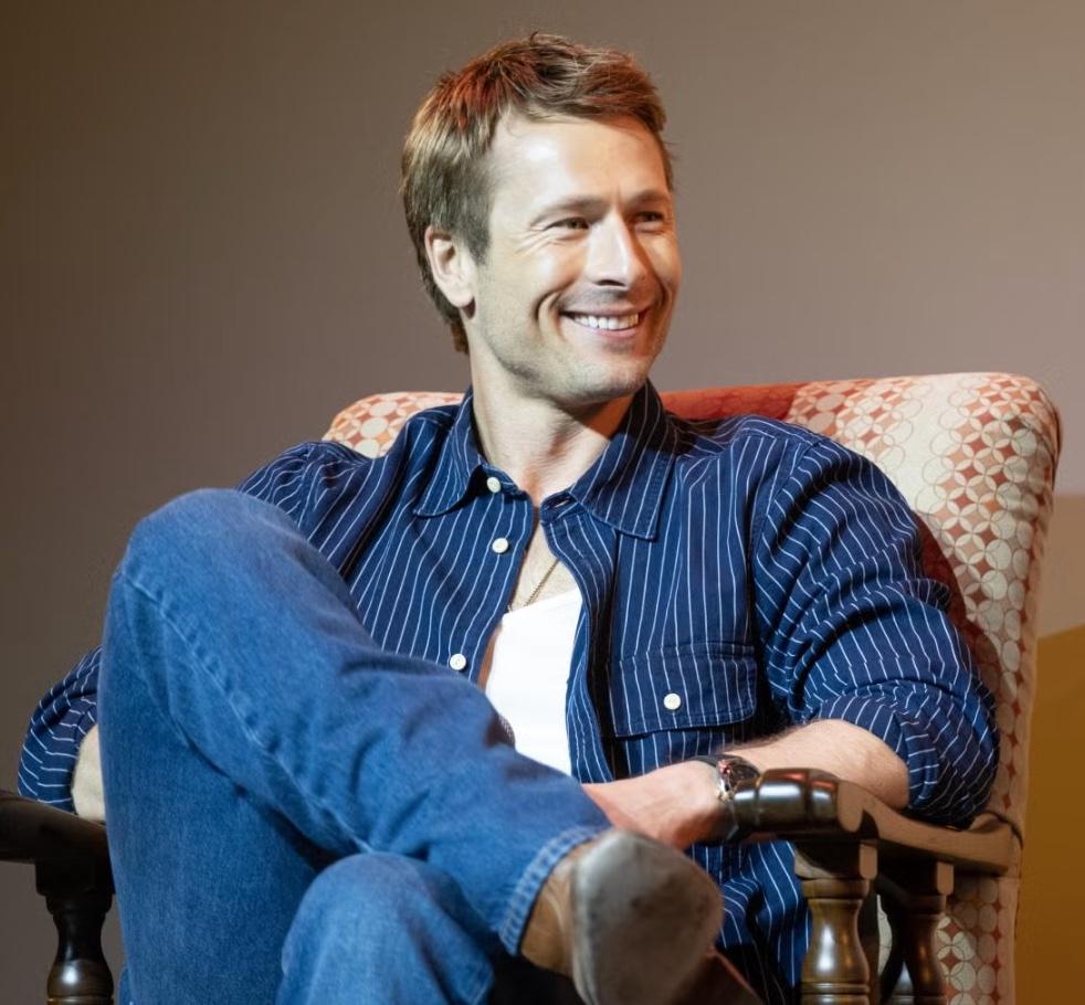Glen Powell sits in an armchair during the Q&A portion of the screening event