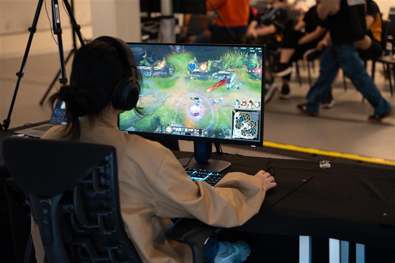 A view over the shoulder of a student playing a video game at a computer